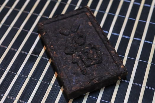 Pressed tea brick with Chinese hieroglyphs. Press tea texture.