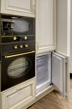 A fragment of a modern interior with a refrigerator and an oven.