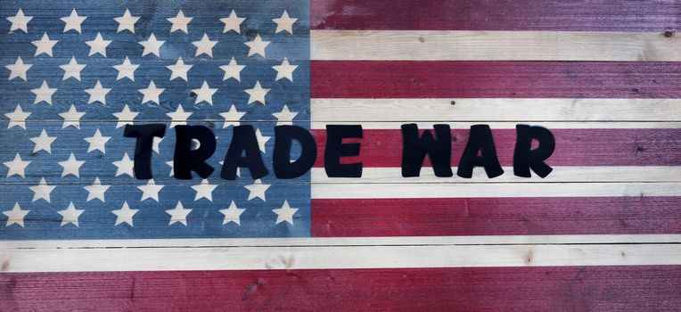 Text letters spelling trade war on vintage wooden United States flag