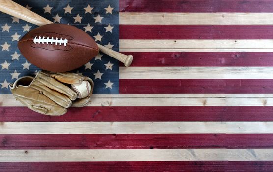 American baseball and football equipment on vintage wooden US flag background. USA sports concept with copy space