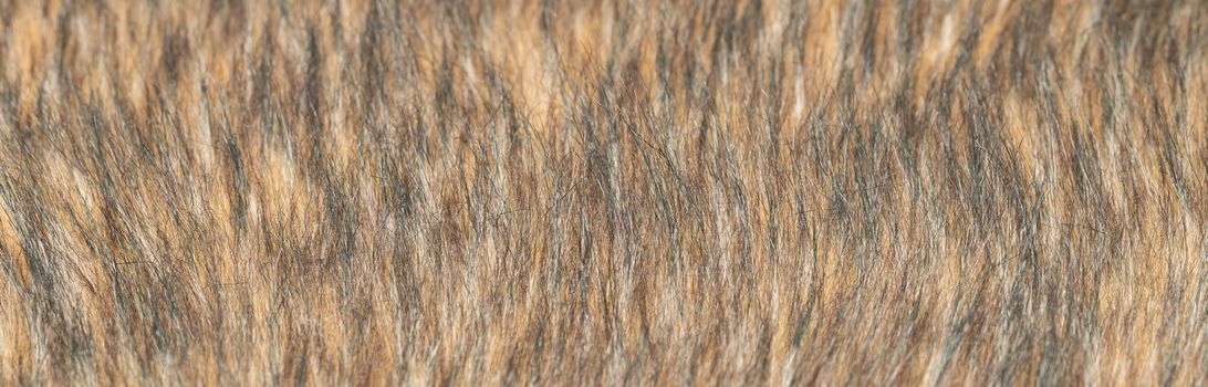 Close-up of a fluffy dark brown faux fur fabric with a background texture. Brown artificial fabric, can be used as a background. Fur for toys or clothing. Eco-friendly replacement of natural fur.