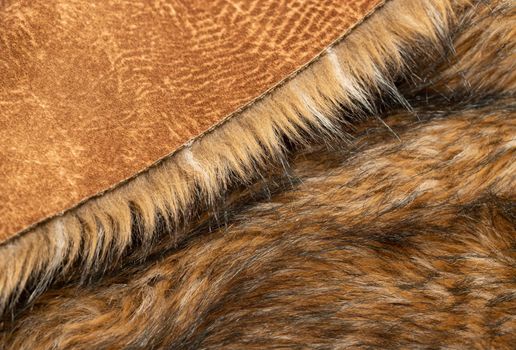 Close-up of a fluffy dark brown faux fur fabric with a background texture. Brown artificial fabric, can be used as a background. Fur for toys or clothing. Eco-friendly replacement of natural fur.