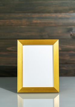 Picture golden frame mock up over table with wood wall background