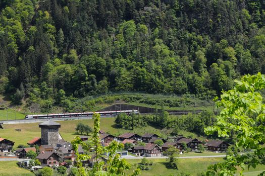 swiss village of Amsteg and Silenen in canton uri, Switzerland with Chruch and Train