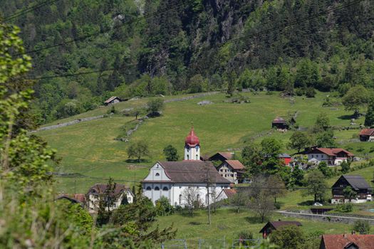 swiss village of Amsteg and Silenen in canton uri, Switzerland with Chruch and Train