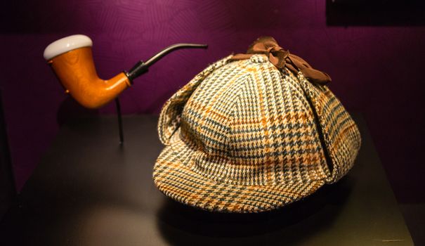 A houndstooth deer stalker hat and a briar pipe made famous by fictional detective, Sherlock Holmes