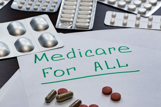 The Medicare for all sign is written on the sheet in green letters, next to the pills.