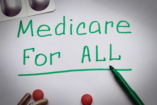 The Medicare for all sign is written on the sheet in green letters, next to the pills.