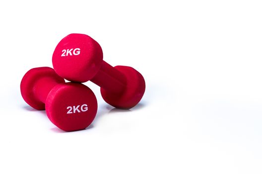 Set of red dumbbells isolated on white background. A pair of red neoprene dumbbells. Home gym equipment for exercise at home. Weight training equipment for sculpt arms, shoulders, back, and legs.