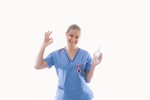 Nurse recommending use of hand sanitizer alcohol rub for hand hygiene during COVID-19 coronavirus influenza pandemic