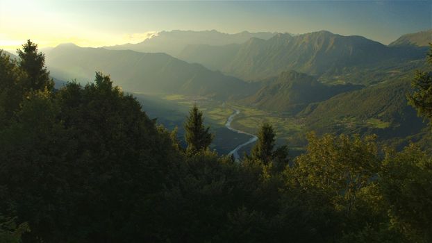 AERIAL VIEW. Meandering river winding through mountain valley in misty morning