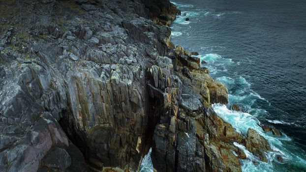 Tilt Up Along Ireland Coast - Waves Crashing on Cliffside