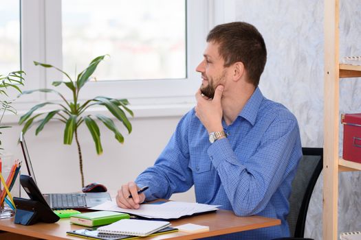 Office worker joyfully looks out the window while waiting for the weekend