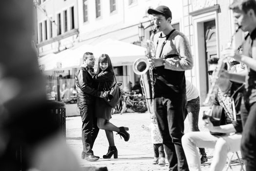 happy guy and girl walking along the tourist streets of old Europe in the city of Gdansk