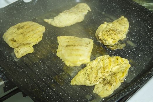 Close up of chicken fillet on stone non-sticky grill pan