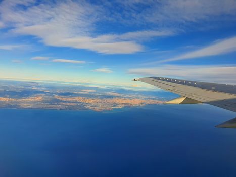 Airplane wing over sea and Barcelona cityscape