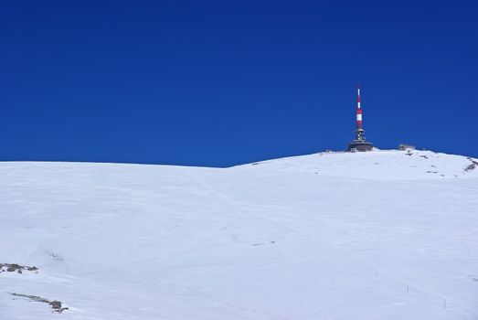 Transmission tower and meteorologic station on white mountain summit, Romanian Carpathians in winter