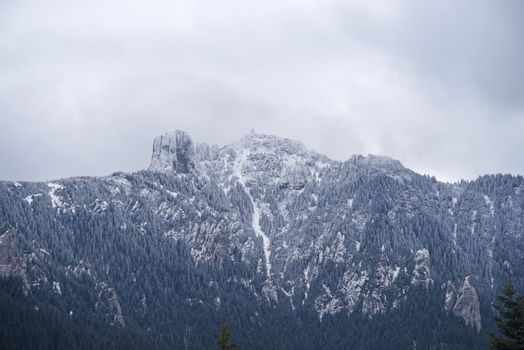 Fresh snow on rocky mountain peak in Romanian Carpathians.