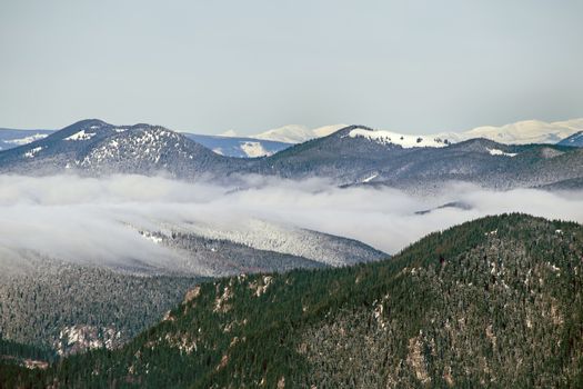 Clouds on the valley in winter mountain landscape