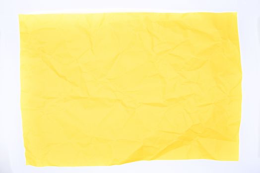 Yellow crumpled paper over a white background