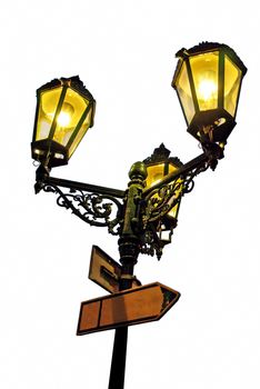 Illuminated old street lamps with touristic boards isolated