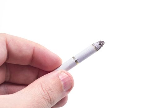 Man holding in hand a burning cigarette over a white background.