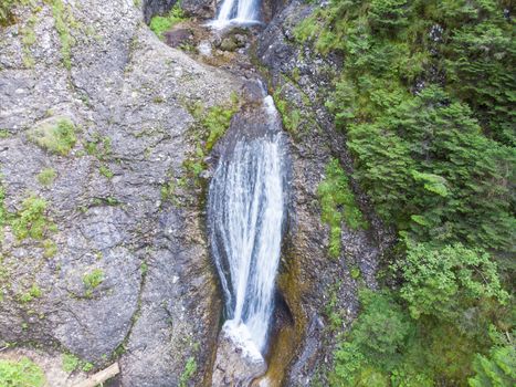 Water stream waterfall on rock in summer mountain, Romanian Carpathians