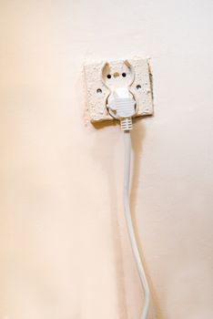 Old electrical socket with power cable pluged in