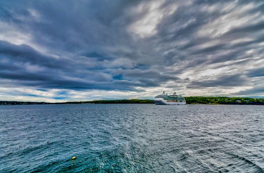 A luxury cruise ship in a harbor on a grey day