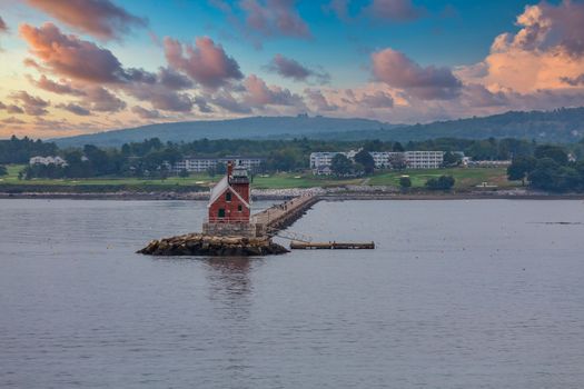 A small red lighthouse on the coast of Maine, near Rockland