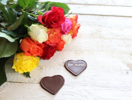 The picture shows colourful roses and chocolate hearts for mother`s day