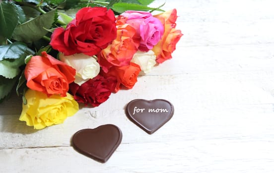 The picture shows colourful roses and chocolate hearts for mother`s day