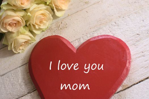 The picture shows white roses and a red heart with the text I love you mom