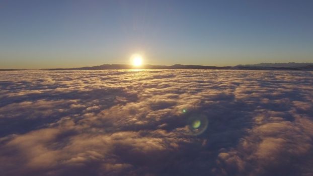 Panorama sunrise from the top of the mount Fuji. The sun is shining strong from the horizon over all the clouds and under the blue sky. good New year new life new beginning. Abstract nature background