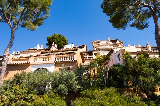 Majorcan architecture with constructions on a hill between two trees