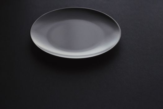 Empty plates on black background, premium dishware for holiday dinner, minimalistic design and diet concept