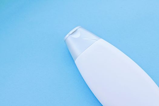 Blank label cosmetic container bottle as product mockup on blue background, hygiene and healthcare