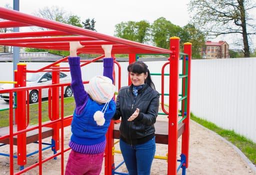 mother playing with her daughter on the playground