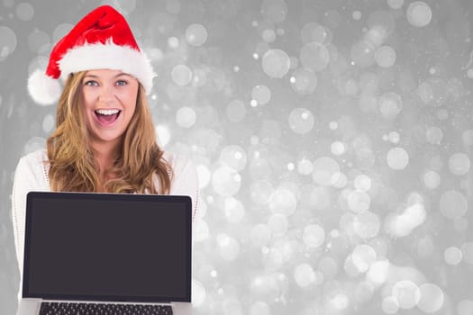 Festive blonde showing a laptop against grey abstract light spot design