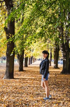 young brunette smiling woman on a walk in the park on sunny autumn day