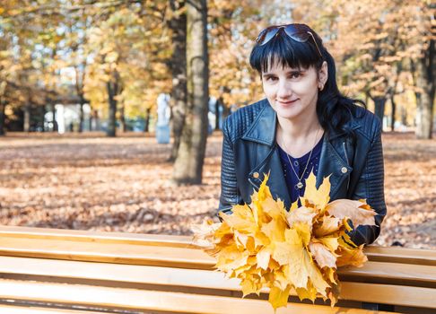 young brunette smiling woman on a walk in the park on sunny autumn day