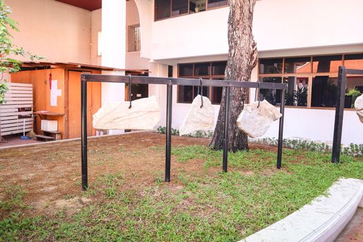 Decorative boulders hanging on a chain in Buddhist temple, Thailand. Lucky rock harmony and stability concept.