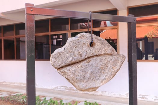 Decorative boulder hanging on a chain in Buddhist temple, Thailand. Lucky rock harmony and stability concept.