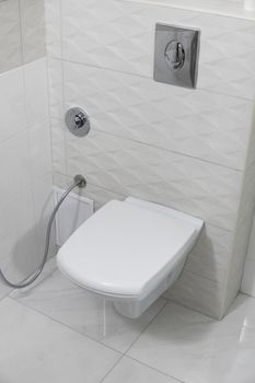 White toilet bowl in modern light bathroom interior