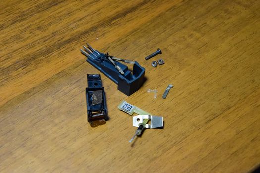 Disassembled vinyl player pickup with a rotary needle.