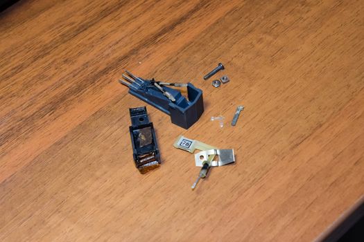 Disassembled vinyl player pickup with a rotary needle.