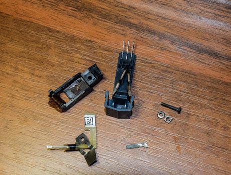Disassembled vinyl player pickup with a rotary needle.