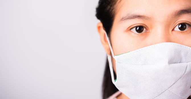 Asian beautiful woman wearing protection face mask against coronavirus her looking to camera, studio shot isolated on white background with copy space, COVID-19 or corona virus concept