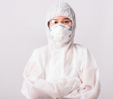 Portrait and closeup Asian female woman doctor or nurse in PPE uniform and gloves wearing face mask protective stand crossed arm in laboratory holding, Health medical coronavirus or COVID-19 concept