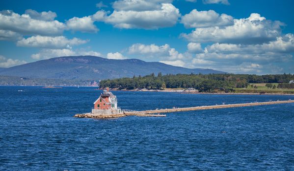 A small red lighthouse on the coast of Maine, near Rockland